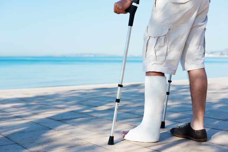 Man on the beach with a cast.