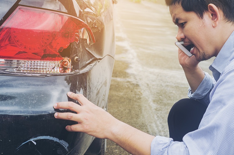 man inspecting minor damage